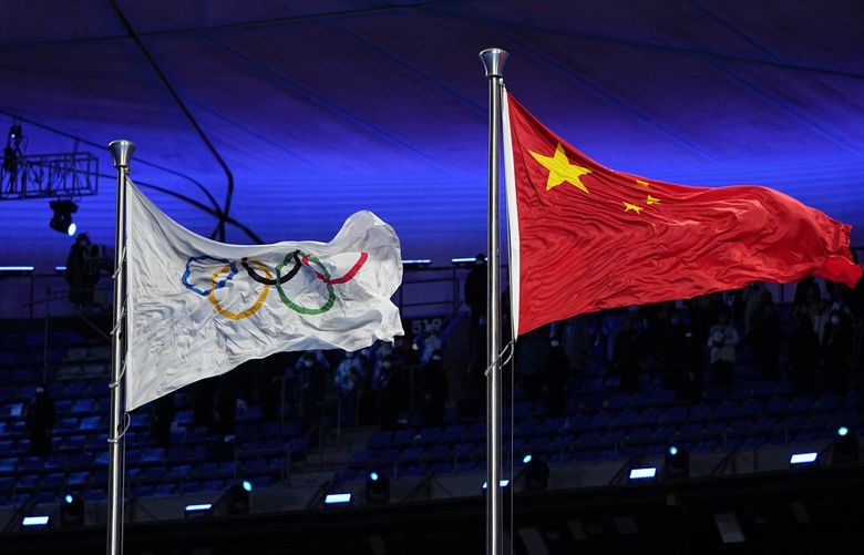 The Chinese and Olympic flags fly during the opening ceremony of the 2022 Winter Olympics, Friday, Feb. 4, 2022, in Beijing. (AP Photo/Jae C. Hong) OLY438 OLY438