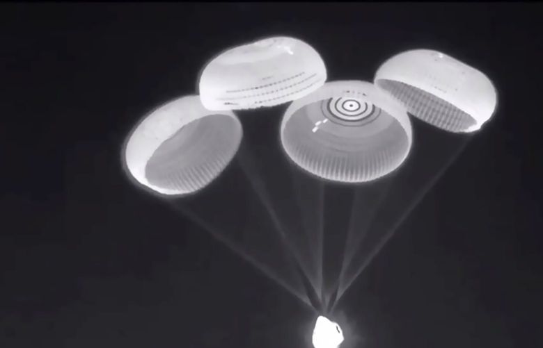In this image taken from NASA video, parachutes are deployed from the SpaceX Dragon capsule, carrying four astronauts, as it descends before splashing down into the Gulf of Mexico near Pensacola, Fla., late Monday Nov. 8, 2021, to end a 200-day space station mission that began last spring. (NASA via AP)