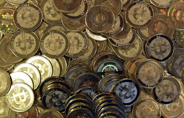 FILE – This April 3, 2013, file photo shows bitcoin tokens. (AP Photo/Rick Bowmer, File)