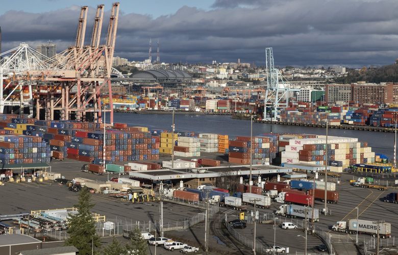 Trucks hauling containers go through a checkpoint (structure at center) before entering the Port of Seattle Friday, November 29, 2021. 218924