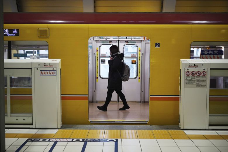 周二，一名妇女在东京穿过火车。 （尤金星子/美联社）