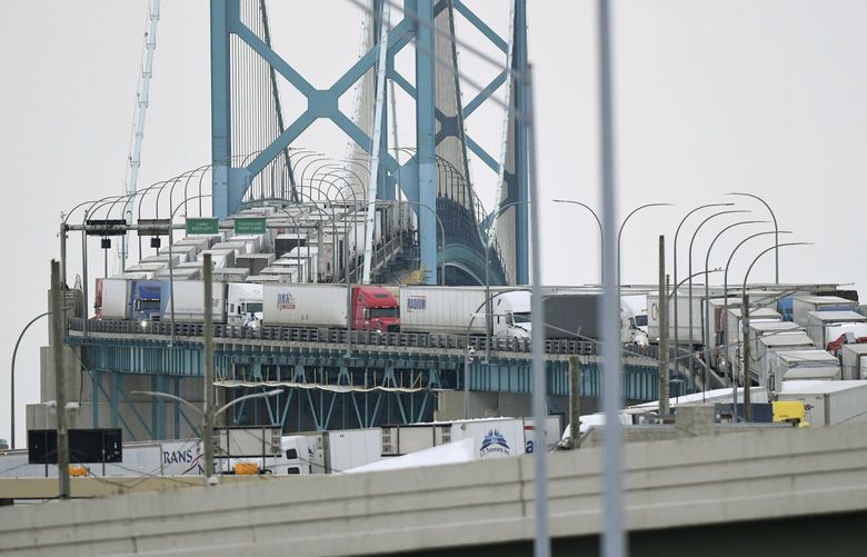 Trucks are backed up heading to and from Canada on the Ambassador Bridge, due to protests on the Windsor side, in Detroit  on Monday, Feb.  7, 2022.   Canada’s public safety minister said Monday that U.S. officials should stay out of his country’s domestic affairs, joining other Canadian leaders in pushing back against prominent Republicans who offered support for the protests of COVID-19 restrictions that have besieged downtown Ottawa for more than a week. (Daniel Mears /Detroit News via AP) MIDTN102 MIDTN102