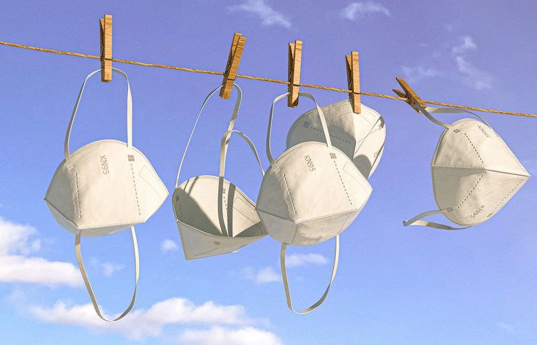 An illustrative image of KN95 masks hanging from a clothesline. With the right care, a high-performance mask can last for multiple uses.  (Delcan & Co./The New York Times) — FOR EDITORIAL USE ONLY WITH NYT STORY SCI MASKS REUSE BY TARA PARKER-POPE FOR FEB. 7, 2022. ALL OTHER USE PROHIBITED. XNYT87 XNYT87