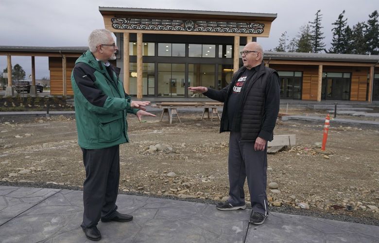 W. Ron Allen, right, chairman of the Jamestown S’Klallam Tribe, talks with Brent Simcosky, left, tribal health director, Wednesday, Feb. 2, 2022, in front of the Jamestown Healing Clinic, in Sequim, Wash. The tribe is building a full-service health center to treat both tribal members and other community residents for opioid addictions. Earlier in the week, Native American tribes across the U.S. settled a lawsuit against drug maker Johnson & Johnson and the largest three drug distribution companies in the U.S. for $590 million. The money won’t be distributed quickly, but tribal leaders say it will play a part in healing their communities from an epidemic that has disproportionately killed Native Americans. (AP Photo/Ted S. Warren) WATW403 WATW403