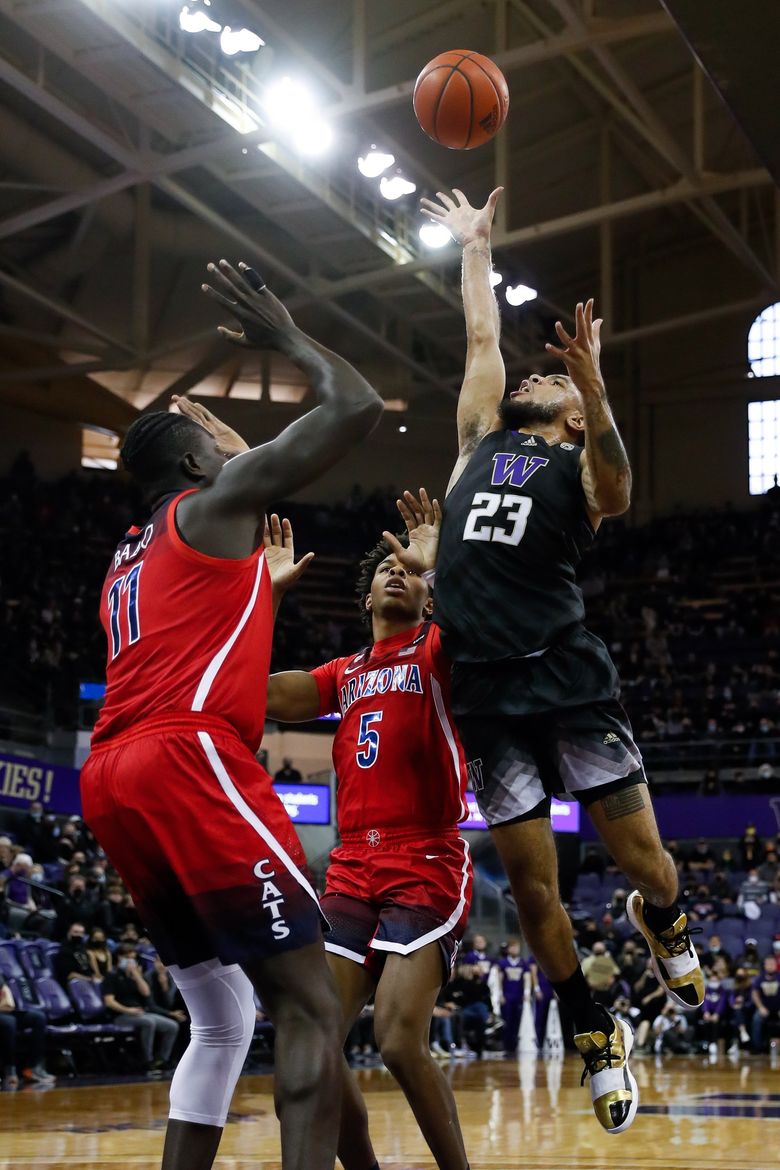 Washington Huskies guard Terrell Brown Jr. elevates over Arizona Wildcats center Oumar Ballo and guard Justin Kier for two of his game high 29 points during the first half Saturday, Feb. 12, 2022 in Seattle, Wash.  (Jennifer Buchanan / The Seattle Times)