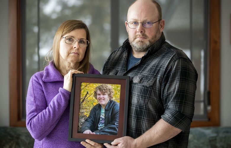 Lisa and Mike Tonseth hold a picture of their 16-year-old son Dylan Tonseth at their home near Cashmere on Saturday, January 29, 2022.

Their son Dylan has autism, low intellectual disability, depression and experiences psychosis. He has struggled with his mental health for several years. 
After several residential and inpatient stays, he ended up in the emergency room at Sacred Heart Children’s in Spokane where he stayed in a windowless room for 33 days. The technical term for when someone like Dylan finds themselves living inside a hospital: Psychiatric boarding.