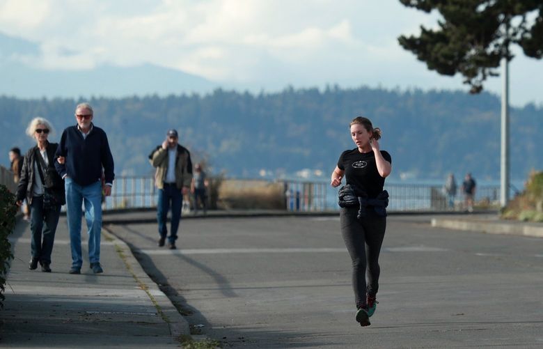 Runners jog on Beach Drive SW on a “Stay Healthy Street” section in West Seattle Wednesday, October 14, 2020. 215350