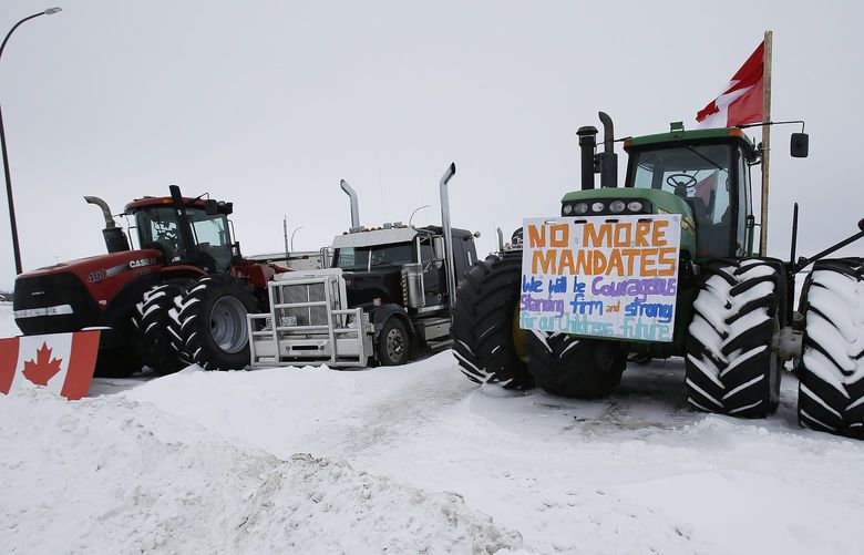 People block highway 75 with heavy trucks and farm equipment and access to the Canada-United States border crossing at Emerson, Manitoba, Thursday, Feb. 10, 2022. The blockade was set up to rally against provincial and federal COVID-19 vaccine mandates and in support of Ottawa protestors. (John Woods/The Canadian Press via AP) JGW106 JGW106