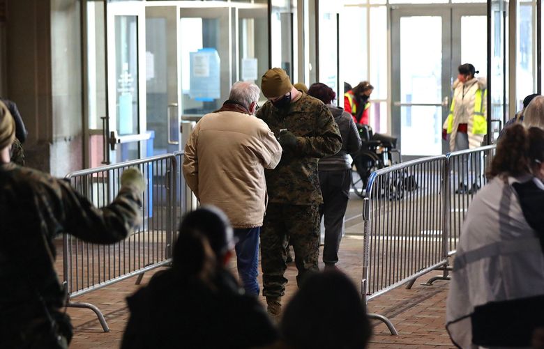 Soldiers check IDs of people as they arrive on the first day of the FEMA COVID-19 vaccination site at the Pennsylvania Convention Center in Center City Philadelphia on Wednesday, March 3, 2021. The omicron surge has caused 9,000 deaths in Pennsylvania since Dec. 1, 2021. (TIM TAI/The Philadelphia Inquirer/TNS) 40453712W 40453712W (TIM TAI / TNS)