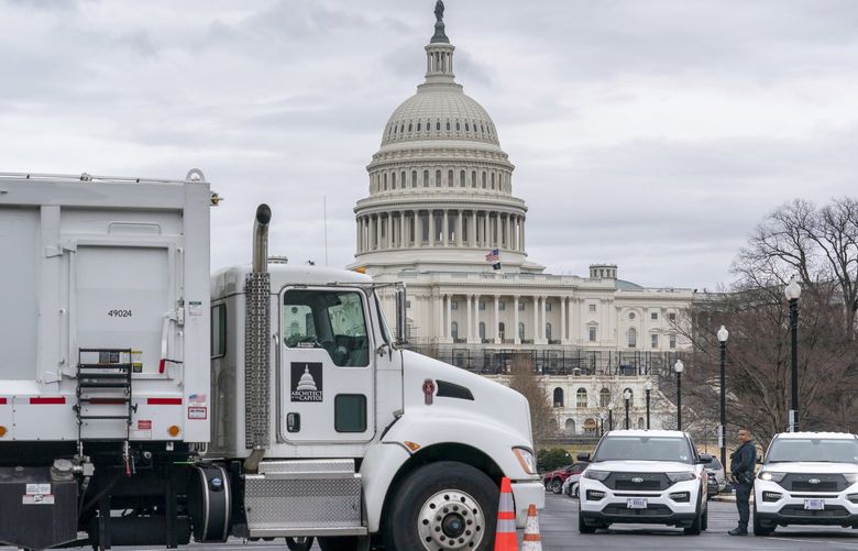 Heavy vehicles, including garbage trucks and snow plows, are set near the entrance to Capitol Hill at Pennsylvania Avenue and 3rd Street NW in Washington, Tuesday, Feb. 22, 2022, amid reports that trucker protests will arrive on March 1, the day of President Joe Biden’s State of the Union address. (AP Photo/J. Scott Applewhite) DCSA101 DCSA101