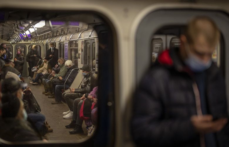 Commuters check their phones while traveling in a local train in Kyiv, Ukraine, Wednesday, Feb. 23, 2022.  (AP Photo / Emilio Morenatti) 