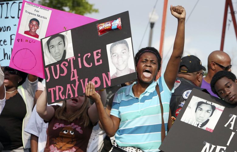 In this March 22, 2012 file photo, protestors, Lakesha Hall, of Sanford, center, and her son, Calvin Simms, right, participate in a rally for Trayvon Martin, the black teenager who was fatally shot by George Zimmerman, a neighborhood watch captain in Sanford, Fla. The killing of Trayvon Martin at the hands of a stranger still reverberates 10 years later — in protest, in partisanship, in racial reckoning and reactionary response, in social justice and social media. (AP Photo/Julie Fletcher, File) CER501 CER501