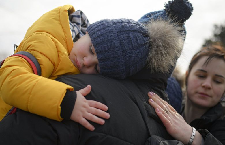 A man hugs his twin boys after they fled the conflict from neighbouring Ukraine at the Romanian-Ukrainian border, in Siret, Romania, Sunday, Feb. 27, 2022. Since Russia launched its offensive on Ukraine, more than 200,000 people have been forced to flee the country to bordering nations like Romania, Poland, Hungary, Moldova, and the Czech Republic â€” in what the U.N. refugee agency, UNHCR, said will have “devastating humanitarian consequences” on civilians. (AP Photo/Andreea Alexandru) XAA808 XAA808