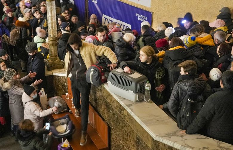 People struggle on stairways after a last minute change on the departure platform for a Lviv bound train in Kyiv, Ukraine, Monday, Feb. 28, 2022. XVG106