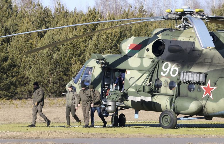 The Ukrainian delegation leaves a Belarusian military helicopter upon their landing in Gomel region, Belarus, Monday, Feb. 28, 2022. The Russian and Ukrainian delegations met for their first talks Monday. The meeting is taking place in Gomel region on the banks of the Pripyat River. (Sergei Kholodilin/BelTA Pool Photo via AP) XAZ114 XAZ114