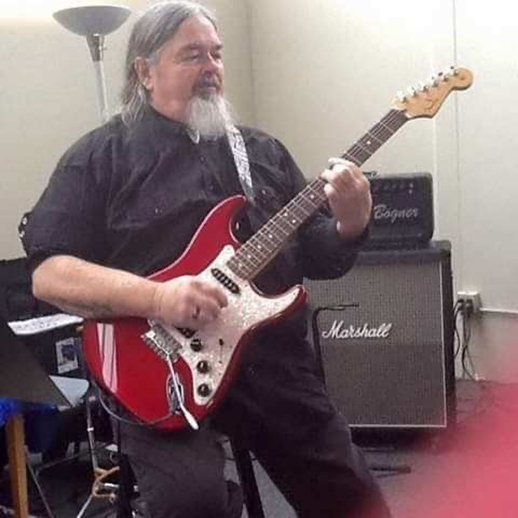 Kenny Williams playing a red electric guitar