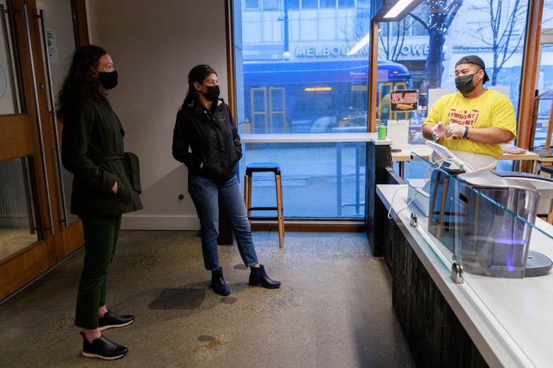 City Attorney Ann Davison, left, talks with Piroshky Piroshky owner Olga Sagan and employees at the bakery’s Third Avenue store in Seattle earlier this month. (Erika Schultz / The Seattle Times)