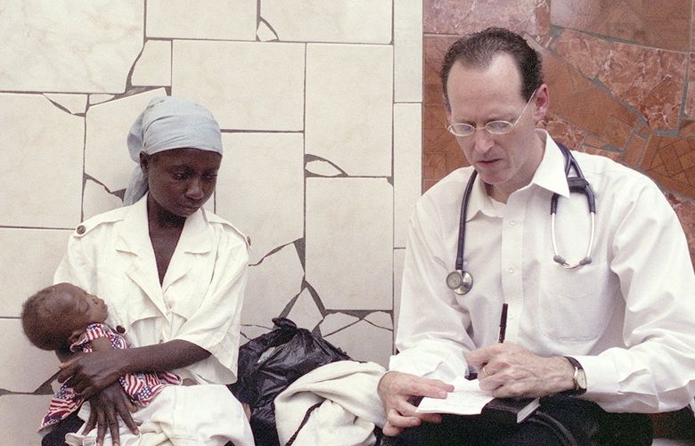 FILE — Dr. Paul Farmer writes a prescription for a pediatric patient at the Partners in Health hospital in Cange, Haiti, Nov. 2003. Farmer, a physician and anthropologist who sought to bring high-quality health care to some of the world’s poorest people, died on Monday, Feb. 21, 2022, in Rwanda. He was 62. (Angel Franco/The New York Times) XNYT51 XNYT51