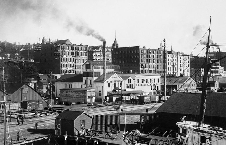 THEN 1: Perched atop the roof of the Seattle Fish Company warehouse on then-Pier 8, Anders Wilse captures a southwest view of Seattle’s late 1890s waterfront. Schwabacher’s Wharf eventually became Pier 57, replaced by Waterfront Park in 1974, which collapsed into Elliott Bay in September 2020. Credit: Anders Wilse / Courtesy Museum of History & Industry