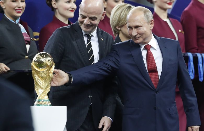 FILE – Russian President Vladimir Putin touches the World Cup trophy as FIFA President Gianni Infantino stands beside him, at the end of the final match between France and Croatia at the 2018 soccer World Cup in the Luzhniki Stadium in Moscow, Russia, Sunday, July 15, 2018. In a sweeping move to isolate and condemn Russia after invading Ukraine, the International Olympic Committee urged sports bodies on Monday to exclude the country’s athletes and officials from international events. The decision opened the way for FIFA, the governing body of soccer, to exclude Russia from a World Cup qualifying playoff match on March 24. Poland has refused to play the scheduled game against Russia.(AP Photo/Petr David Josek, File) TH101 TH101