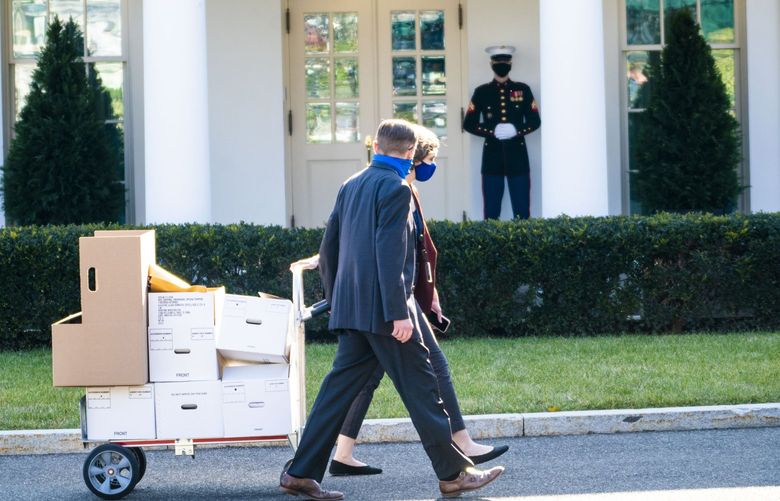 White House staffers wheel a cart laden with boxes past a Marine sentry who stands outside the West Wing of the White House, indicating that president Donald Trump is in the Oval Office, on Wednesday, Jan. 13, 2021.  The House of Representatives on Wednesday began debating whether to advance an article of impeachment that accuses Trump of “inciting an insurrection.” (Doug Mills/The New York Times)