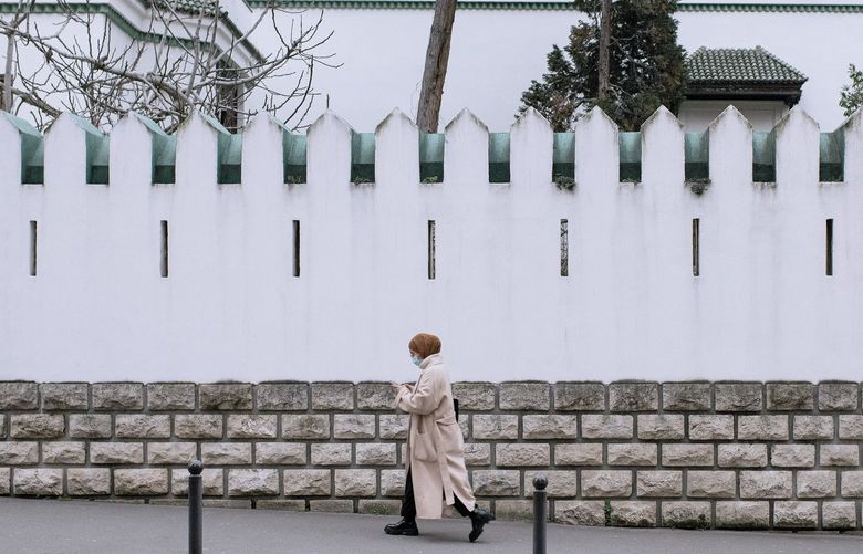 A woman walks near the Grand Mosque of Paris, Jan. 25, 2022. All the talk of France’s presidential election campaign is about immigration, but it is the quiet flight of French Muslims from France that points to a deeper crisis for the country. (Dmitry Kostyukov/The New York Times)