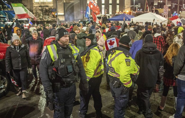 Police walk through the trucker-led protests blocking streets near the Canadian Parliament building in downtown Ottawa, Friday, Feb. 11, 2022. Ottawa police were vastly outnumbered, experts say, and unprepared for the sophisticated tactics, discipline and logistical abilities of the protesters. (Brett Gundlock/The New York Times)

 XNYT37 XNYT37