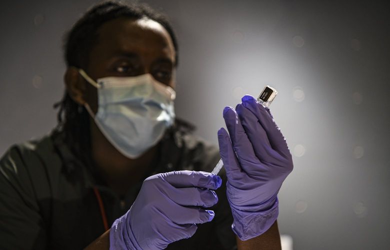 FILE — A nurse prepares a Covid-19 vaccine booster in Washington, Feb. 4, 2022. Data released by the Centers for Disease Control and Prevention on Friday showed that booster shots lost some effectiveness after about four months. (Kenny Holston/The New York Times) XNYT218 XNYT218