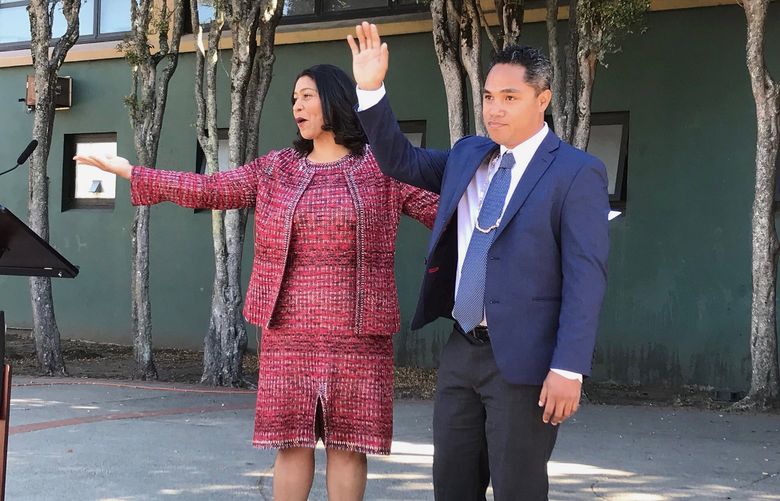 San Francisco Mayor London Breed, left, waves next to Faauuga Moliga, who she appointed to the school board, Oct. 15, 2018, in San Francisco. In a city with the lowest percentage of children of all major American cities, school board elections in San Francisco have often been an afterthought. A special election on Feb. 15, 2022, will decide the fate of three school board members, all Democrats, including Moliga, in a vote that has divided the famously liberal city. (Jill Tucker/San Francisco Chronicle via AP) CAFRA802 CAFRA802