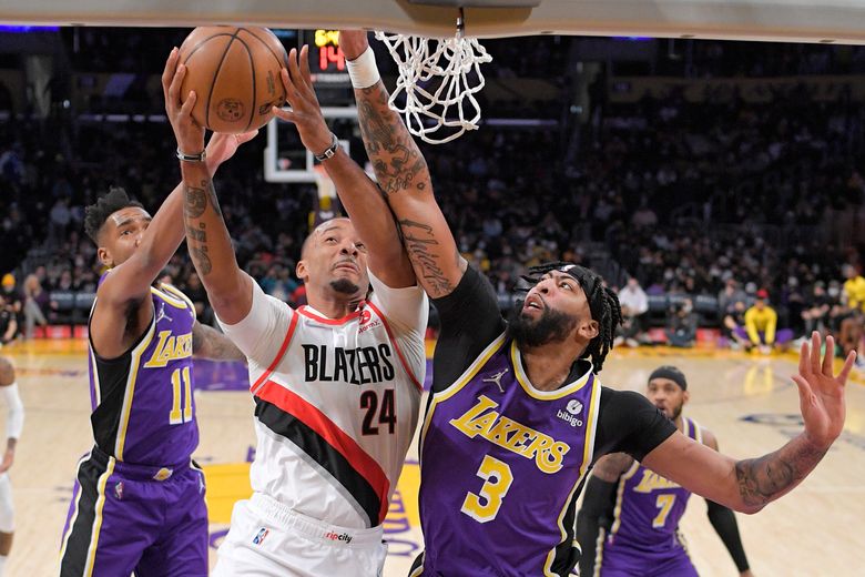 Portland Trail Blazers guard Anfernee Simons, second from left, shoots as  Los Angeles Lakers forward LeBron James defends during the first half of an  NBA basketball game Wednesday, Nov. 30, 2022, in
