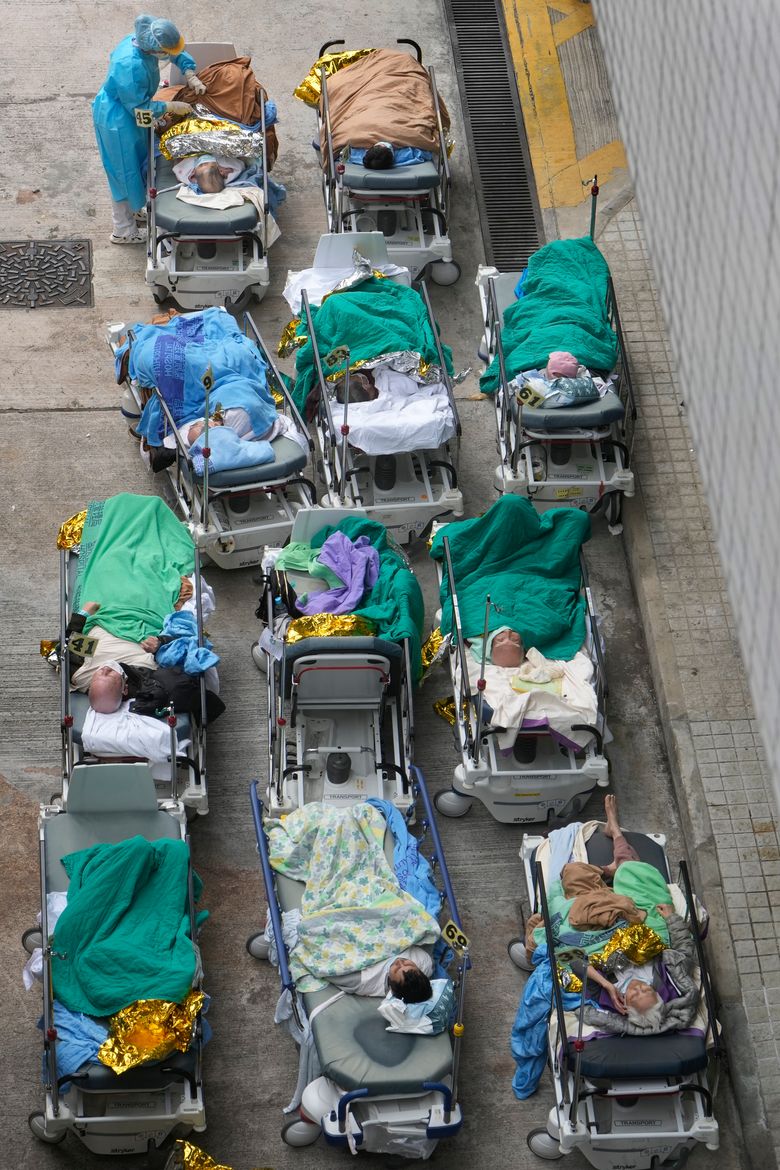 2022 年 2 月 16 日，星期三，患者躺在医院病床上等待在香港明爱医疗中心外的临时收容区。有明显的证据表明，香港医院正因最新的 COVID 激增而不堪重负，担架和担架上的患者周三，医务人员在明爱医院外的帐篷里接受治疗。 （美联社照片文森特于）