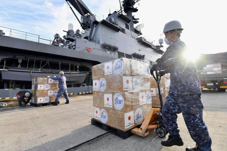 2022 年 1 月 24 日,日本海上自卫队成员将前往汤加的紧急救援物资装载到日本西部广岛附近的吴市的一艘船上。太平洋群岛国家汤加在发现其首次社区传播后处于封锁状态COVID-19 似乎是由上个月的火山爆发和海啸后运送淡水和药品的援助人员带来的。 (Shingo Nishizume/Kyodo News via AP)