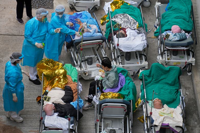 2022 年 2 月 16 日,星期三,患者躺在医院病床上,在香港明爱医疗中心外的临时收容区等候。尽管严格遵守零新冠病毒战略,但香港的限制措施已经让曾经的繁华不再城市,现在许多人担心最坏的情况还没有到来,香港正在经历迄今为止最严重的疫情。 (美联社照片/Vincent Yu)