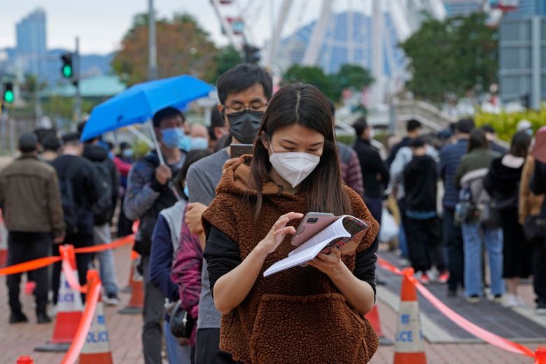 2022 年 2 月 8 日,星期二,居民在香港的 COVID-19 临时检测中心排队接受冠状病毒检测。农历新年假期后,香港本地 COVID-19 感染人数激增。 (美联社照片/Kin Cheung)