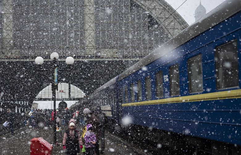 A Ukrainian family take the Dnipro-Truskavets at the Lviv railway station, Sunday, Feb. 27, 2022, in Lviv, west Ukraine. (AP Photo/Bernat Armangue) ALY813 ALY813
