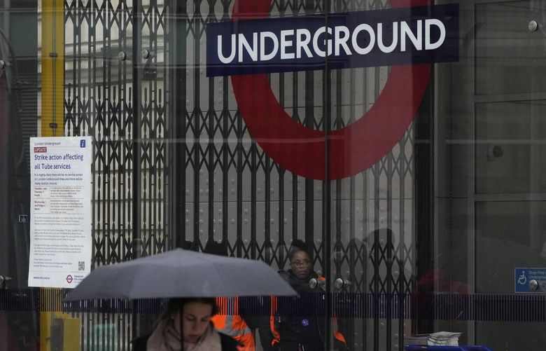 A London Underground worker seen through the closed barriers of a tube station, during a strike by members of the Rail, Maritime and Transport union (RMT), in central London, Tuesday, March 1, 2022. Travellers in London are being warned of severe disruption to Tube services because of strikes by thousands of workers in a dispute over jobs, pensions and conditions. (AP Photo/Alastair Grant) XAG102 XAG102