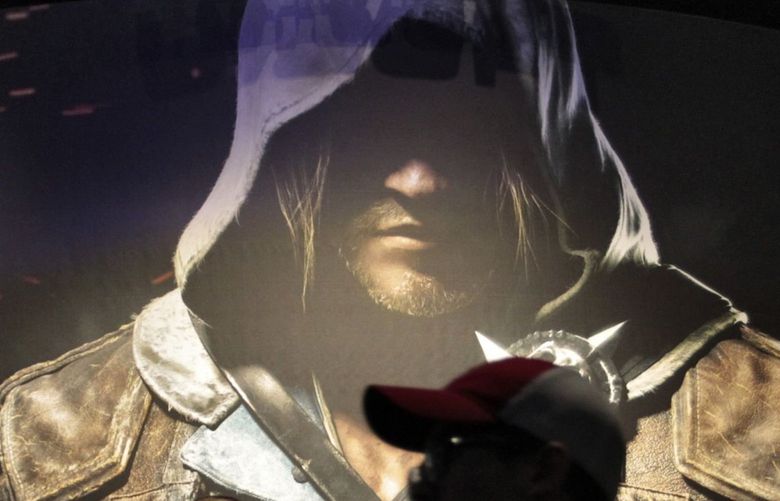 Attendees walk past an image from Ubisoft Entertainment’s Assassin’s Creed IV: Black Flag video game during the E3 Electronic Entertainment Expo in Los Angeles, California, U.S., on Tuesday, June 11, 2013. E3, a trade show for computer and video games, draws professionals to experience the future of interactive entertainment as well as to see new technologies and never-before-seen products. Photographer: Jonathan Alcorn/Bloomberg 170418014