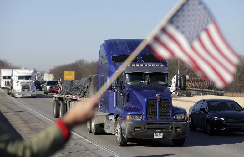 Supporters watch as “The People’s Convoy” passes by on the Will Rogers Turnpike Monday, Feb. 28, 2022 in Vinita, Okla.   The convoy is traveling from California to Washington D.C. to protest COVID-19 restrictions. (Mike Simons/Tulsa World via AP) OKTUL101 OKTUL101