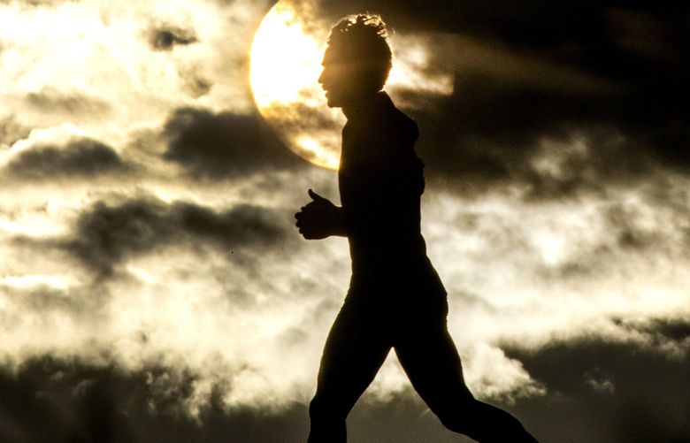 A runner is framed against the setting sun while moving down the Lewiston Levee Parkway Trail on Tuesday, Feb. 15, 2022, in Lewiston, Idaho. (August Frank/The Lewiston Tribune via AP) IDLEW601 IDLEW601