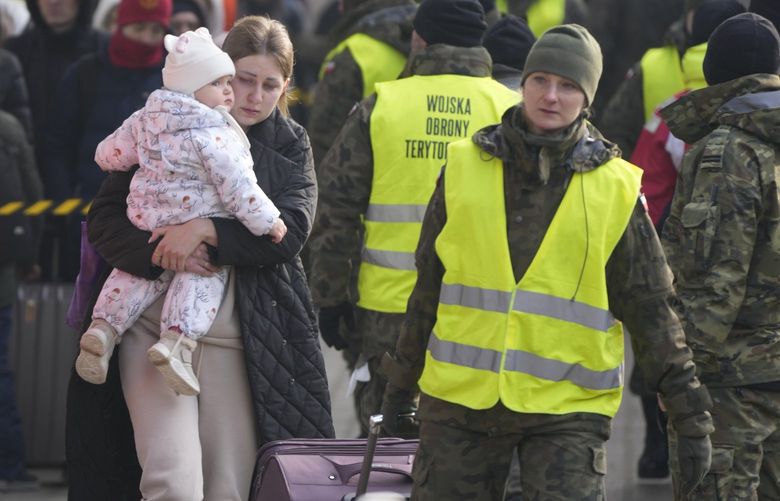 A woman holds a child as she arrives with other displaced Ukrainians after they arrived on a train at the station in Przemysl, Poland, Thursday, March 3, 2022. More than 1 million people have fled Ukraine following Russia’s invasion in the swiftest refugee exodus in this century, the United Nations said Thursday. (AP Photo/Markus Schreiber) XVLM118 XVLM118