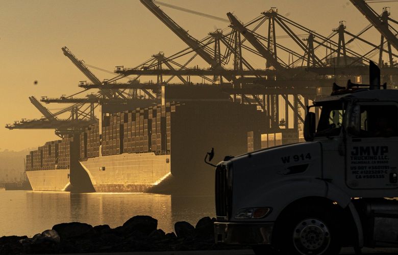 FILE – A truck arrives to pick up a shipping container near vessels moored at Maersk APM Terminals Pacific at the Port of Los Angeles, on Nov. 30, 2021. (AP Photo/Damian Dovarganes, File)