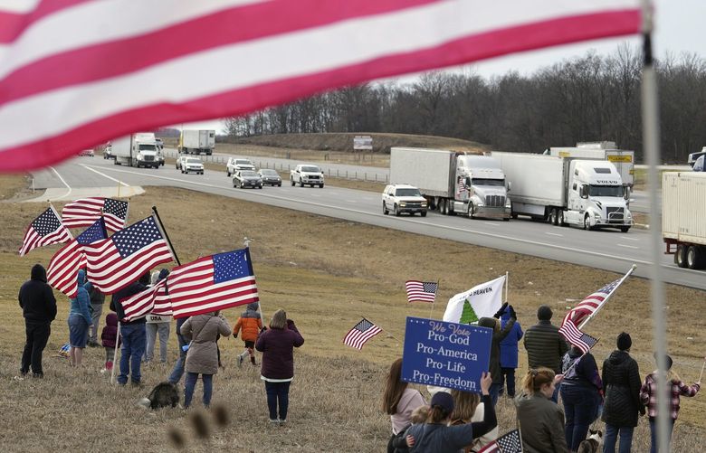 Supporters cheer as the People’s Convoy passes by on Interstate 70 in West Jefferson, Ohio, Thursday, March 3, 2022. About 150 gathered at the Ohio Route 142 bridge over I-70 in Madison County, just a few miles west of Columbus, Ohio. (Doral Chenoweth/The Columbus Dispatch via AP) OHCOL401 OHCOL401