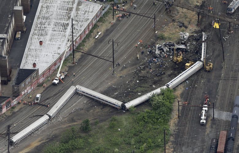 FILE- In this Wednesday, May 13, 2015, file photo, emergency personnel work at the scene of a derailment in Philadelphia of an Amtrak train headed to New York. A Philadelphia jury is expected weigh criminal charges Friday, March 4, 2022, against Amtrak engineer Brandon Bostian over the deadly derailment. (AP Photo/Patrick Semansky, File) PAMR115 PAMR115