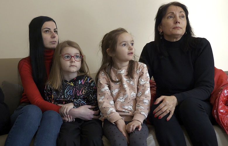 Lilia Kosovich, right, her daughter-in-law, Khrystyna Kosovich, left, and Iryna Kozoriz, second left, and her daughters Kamila and Anastasia, sit on a sofa during an interview with the Associated Press in Berlin, Germany, Tuesday, March 1, 2022. As Russia’s war in Ukraine drags into its second week, more than 1.5 million Ukrainians immigrants living in other European countries, are watching on in agony, horror and fear as their relatives and friends back home are looking for shelter in bunkers or are desperately trying to flee the country. (AP Photo/Pietro De Cristofaro) SOB106 SOB106