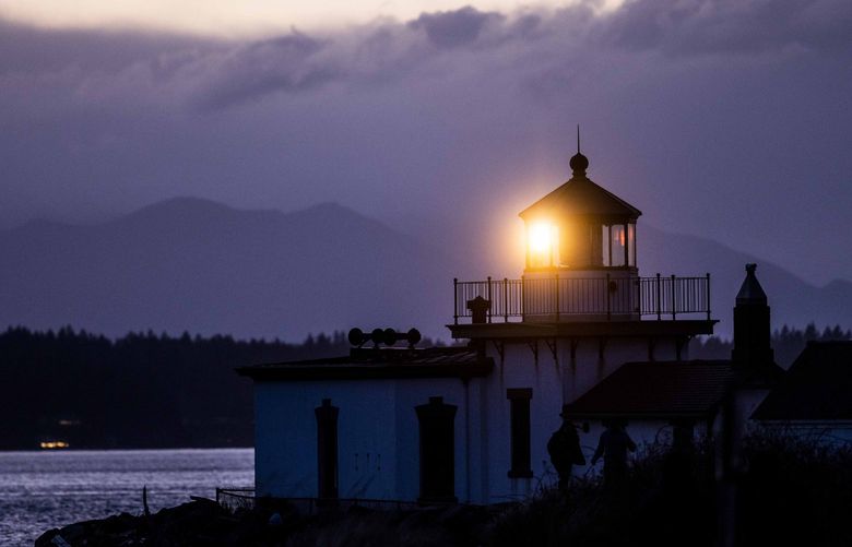 The lighthouse beams after the sun set over the horizon at Discovery Park on March 1, 2022. LO