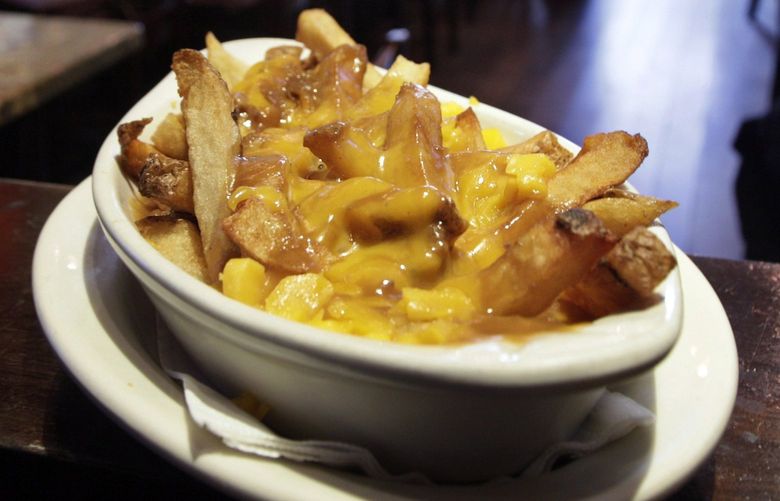 This photo taken Jan. 11, 2010 shows a serving of poutine  at New York’s Dive Bar. This guilty pleasure of extra-crispy french fries, meaty gravy and cheese curds has been called the national dish of Canada. (AP Photo/Richard Drew) NYLS109