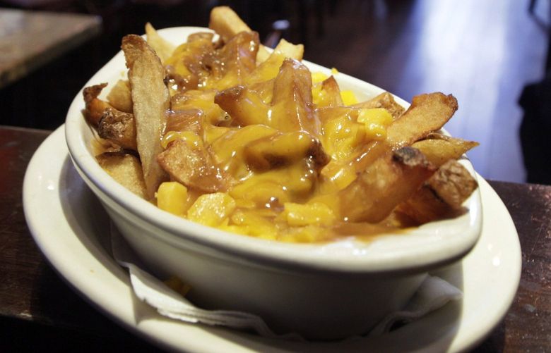 This photo taken Jan. 11, 2010 shows a serving of poutine at New York’s Dive Bar. This guilty pleasure of extra-crispy french fries, meaty gravy and cheese curds has been called the national dish of Canada. (AP Photo/Richard Drew) NYLS109
