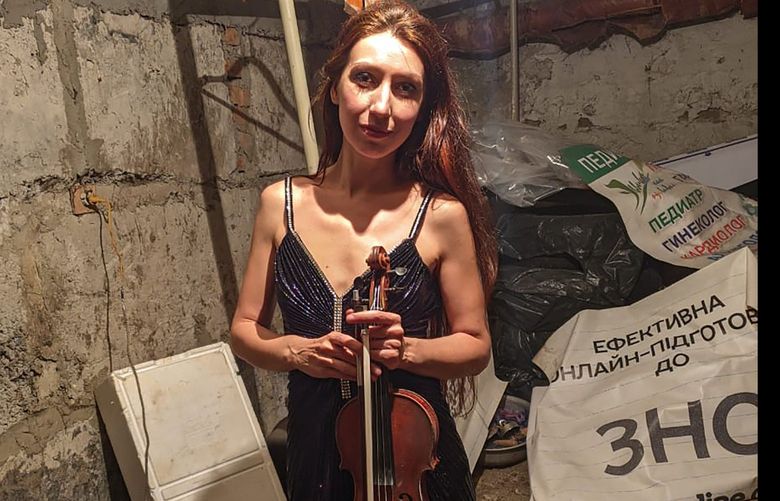 Vera Lytochenko holds her violin as she poses for a photo in a basement of an apartment building in Kharkiv, Ukraine, Sunday March 6, 2022. Lytochenko is Ukraine’s cellar violinist, who has become an internet icon of resilience as images of her playing in the basement bomb shelter have inspired an international audience via social media. (Vera Lytochenko via AP) TH810 TH810