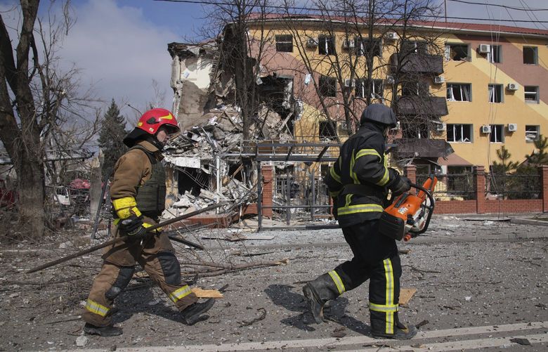 Firefighters walk past a damaged by shelling building in Mariupol, Ukraine, Thursday, March 10, 2022. (AP Photo/Evgeniy Maloletka) XB115 XB115