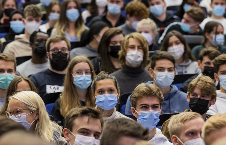 FILE -Students wear mouth-to-nose coverings while sitting close to each other during the lecture “BWL 1” in lecture hall H1 of the Westfaelische Wilhelms-Universitaet in Muenster, Germany, Monday, Oct. 11, 2021. Germany’s health minister pleaded with his compatriots Friday not to assume that the coronavirus pandemic is over as the country sees a steady rise in new cases, warning that it is still in a â€œcriticalâ€ situation. (Rolf Vennenbernd/dpa via AP, file) MAS101 MAS101